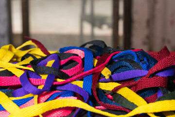colorful shoelaces background, on black wood, messy, clutter concept, advertisement