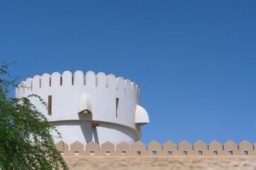 Fragment of bastion fort wall and part of watchtower in Abu Dhabi,UAE. Defensive middle eastern city wall with prongs. Fortification renovation.