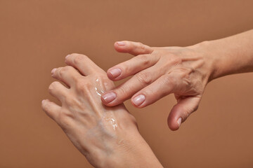 Crop female applying lotion on hand