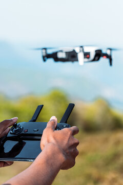 Man controlling drone with controller in nature