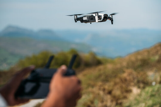 black woman controlling drone with controller in nature