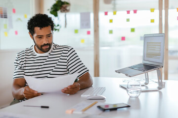 Serious man working with documents at workplace