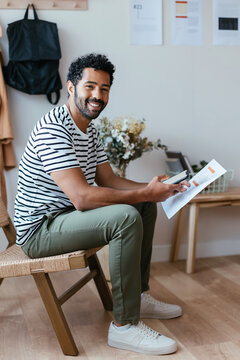 Happy man with smartphone and document looking at camera