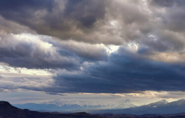 Fototapeta na wymiar Enormi nuvole grigio azzurre sopra le montagne e le valli dell’Appennino