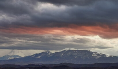 Obraz na płótnie Canvas Nuvole rosse sopra le cime innevate dei monti Appennini