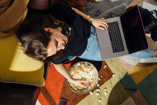 Young Woman with Popcorn and Laptop