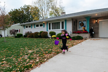 Children running from house to house for Halloween candy. 
