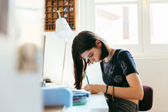 Cute girl drawing at her desk
