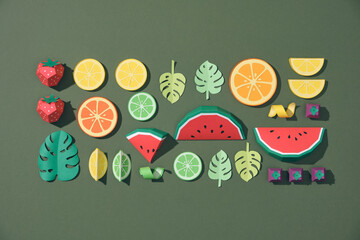 exotic fruits made of paper on green background