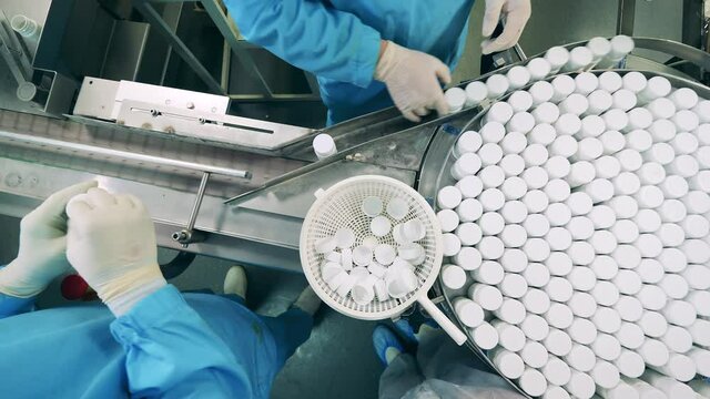 Manual sealing and conveyor transportation of pill bottles