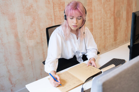 Woman Taking Notes At Call Center