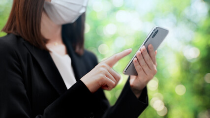 木々の前に立つビジネスウーマン