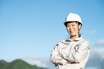 カメラ目線の作業着の中年女性 コピースペースあり