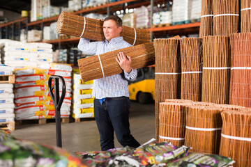 Customer buying decorative wicker fence in hardware store. High quality photo