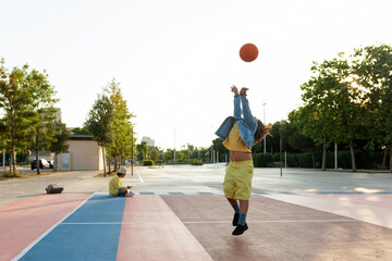 Kids playing basketball after school at sports area