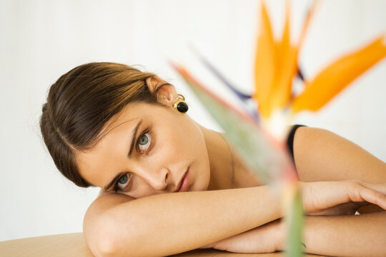 Portrait Of A Young Woman Leaning On A  Behind A Flower