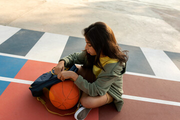 Girl sitting at basketball court