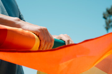 man rolling a rainbow pride flag
