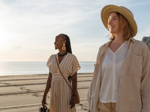 Happy diverse women resting on beach