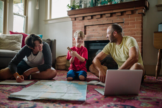 Boys laughing with dad while planning trip