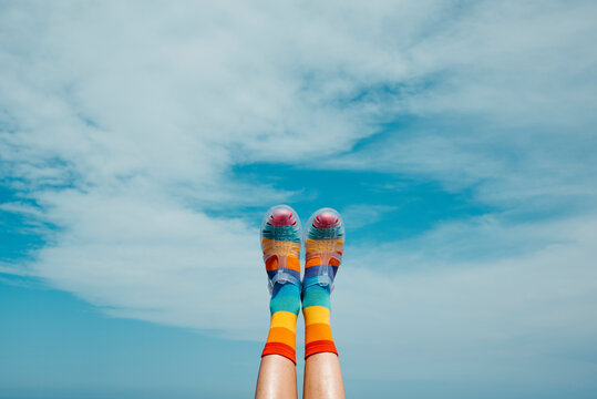 rainbow patterned socks and sandals against the sky