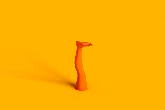 orange human leg on yellow background