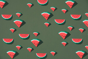 pattern of watermelon slices with seeds on the green background.