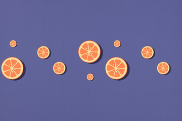 Fruit pattern with sliced oranges make from paper on purple paper background