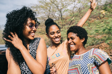 Affectionate young black young women friends standing on street