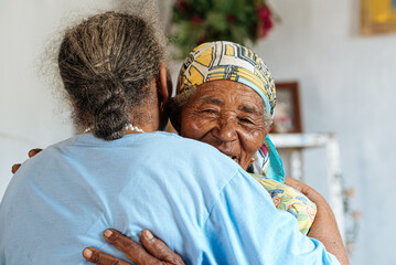 Senior females hugging indoors