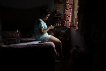 Teenage girl browsing internet in smartphone  in room 
