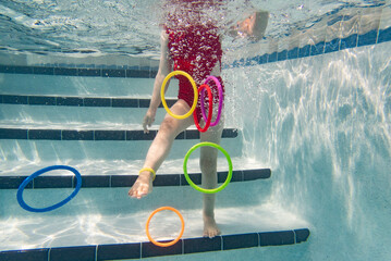 Little girl with underwater dive rings.