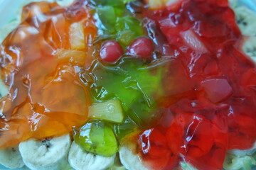 Creamy custard jelly sweet dish with different slices layered on surface