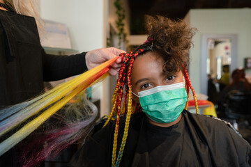 Camera aware masked girl getting box braids