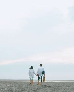 The Back Of Couple Walking On The Beach