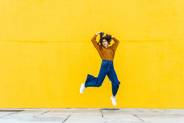 Young woman having fun outdoors jumping and dancing