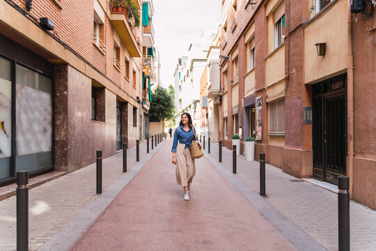 Smiling woman walking on empty city street