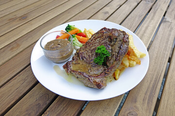 Wagyu beef steak served with vegetables and French fries. Selective focus