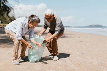 Senior couple collecting rubbish at the beach. environmental protection concept and Good role model
