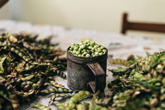 Shelled green beans in a mug on table