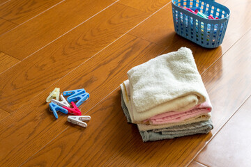 木の床の上に置かれた洗濯物と洗濯バサミ