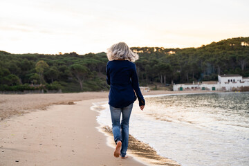 Mature woman walking on beach 