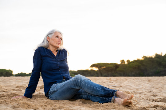 Beautiful mature woman sitting relaxing at beach