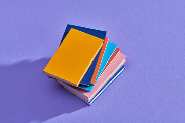 stack of books isolated on lilac
