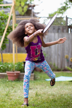 Young girl lunging forward to return a birdie