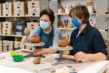 Craftswoman apprentice potter with her teacher.