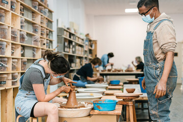 Black potter observing an apprentice in the workshop