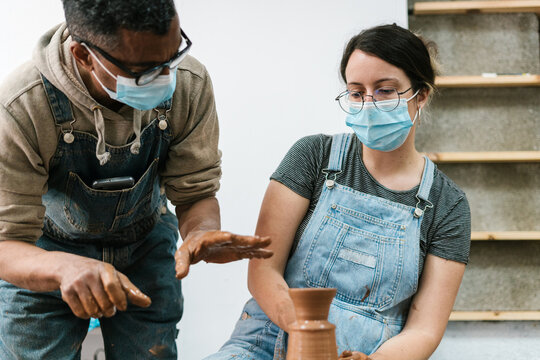 Man giving advice to a woman on how to use a lathe