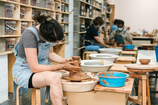 Craftswoman working with clay during pottery lesson