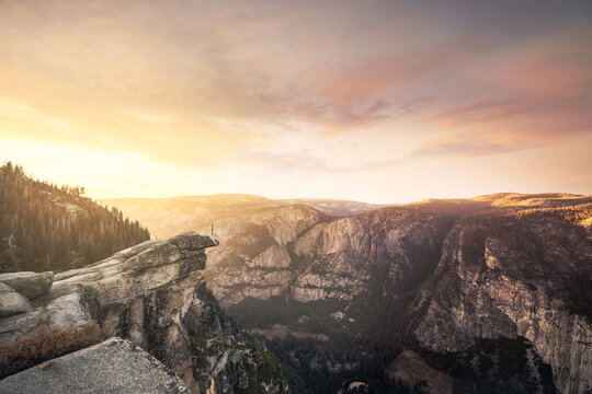 Tiny person over a rock over the awesome cliffs of Yosemite